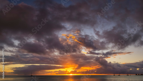A sunset sky with red and orange colors over the ocean as background or texture © moofushi