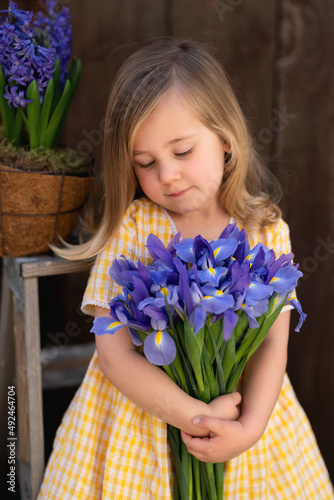 A girl is holding a bouquet of violet flowers