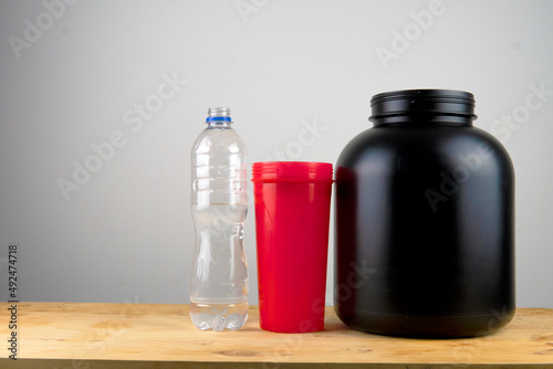 bodybuilding, healthy lifestyle concept. Whey protein powder, blender or shaker, and a bottle of water