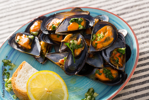 Photography of plate with mussels under lemon sauce in restaurante.