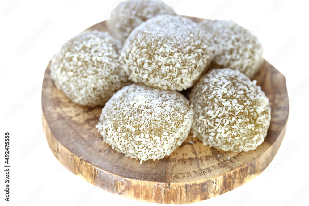 mochi cakes.Coconut mochi on a round board isolated on white background. Japanese traditional dessert with coconut. mochi cakes.Coconut mochi on a round board isolated on white background. Japanese traditional dessert with coconut.