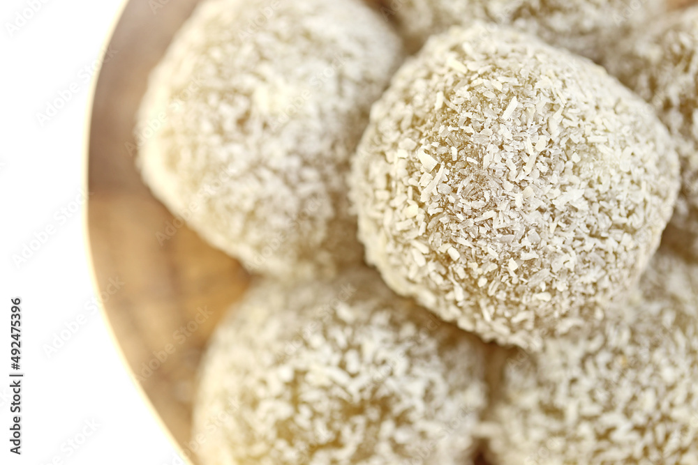 mochi cakes.Coconut mochi on a wooden round board isolated on white background. Japanese dessert with coconut. mochi cakes.Coconut mochi on a wooden round board isolated on white background. Japanese dessert with coconut.