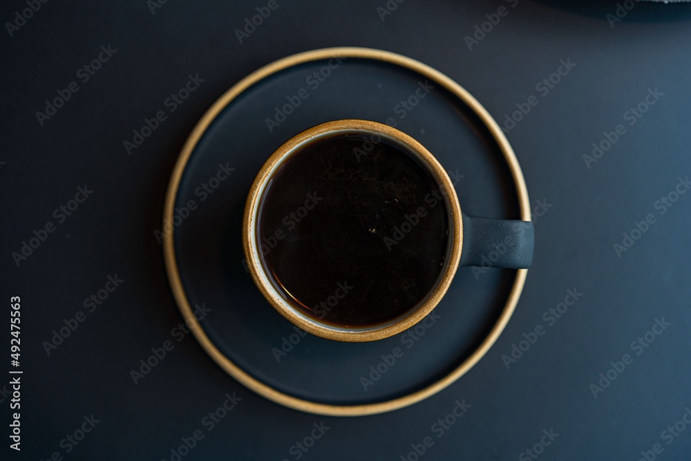 coffee in a black cup . Black coffee cup, on a black background. Space for text. top view