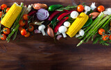 Ingredients for vegetarian dishes. Fresh raw mushrooms, vegetables, herbs and seasonings on wooden surface