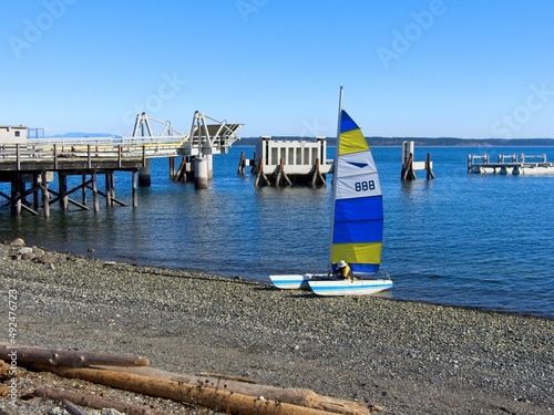 Sail boat near the shore of Sidney BC with sail colored in yellow and blue as national flag of Ukraine in sign of support © pr2is