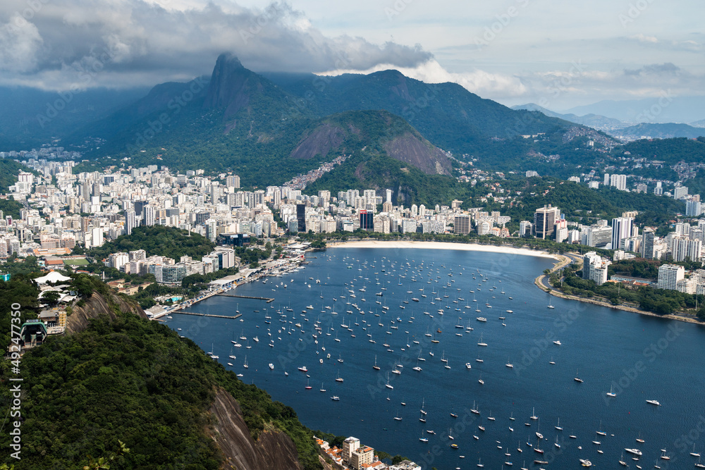 Aerial image of Botafogo and Flamengo cove and beach with its buildings, boats and landscape. Sugarloaf Mountain and the cable car. Immensity of the city of Rio de Janeiro, Brazil in the background
