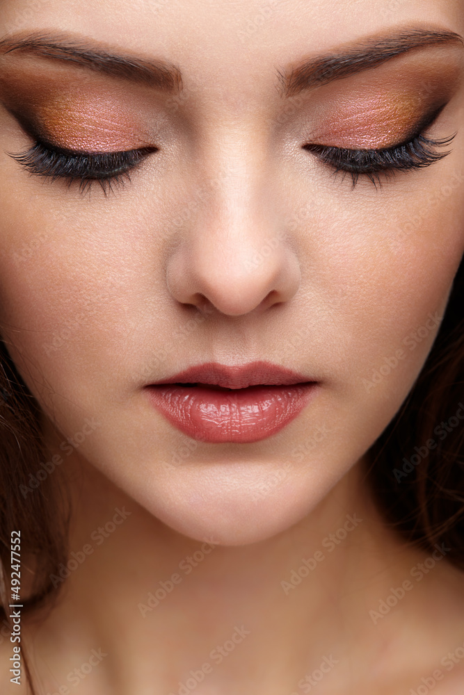 Closeup portrait of female face with red lips and smoky eyes beauty makeup.