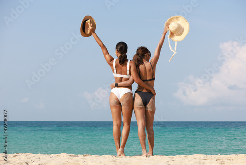Portrait back view of tanned girl hug the waist and hand up express happy summer vacation, Beautiful girls walking and having fun on the beach
