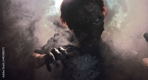 scary sorcerer in smoke. voodoo rite photo