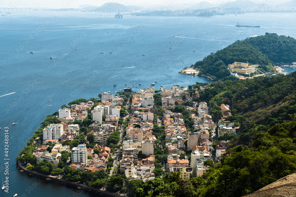 Aerial view of the Urca neighborhood in Rio de Janeiro, Brazil with its old buildings. Surrounded by boats in Guanabara Bay and a landscape full of trees and hills