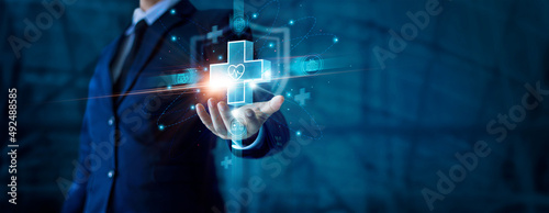 Obraz na plátně Businessman hand holding virtual medical health care icons with medical shield and network connection
