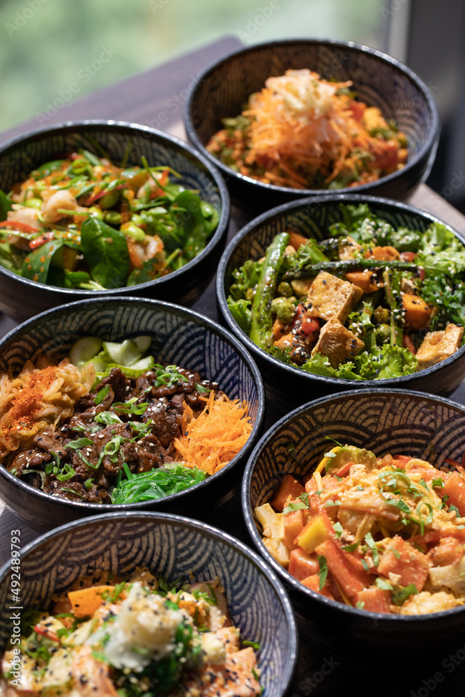 Poke bowls and other gourmet foods, with drinks and sushi on the table, Poke bowls and other gourmet foods, with drinks and sushi on the table,