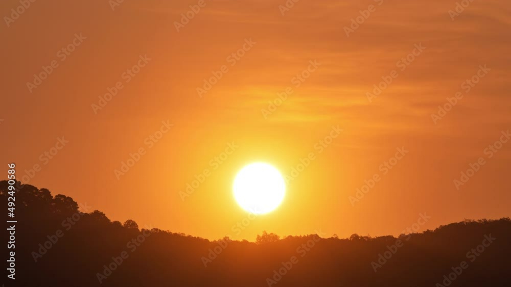 Timelapse of dramatic sunset with orange sky in a sunny day.	