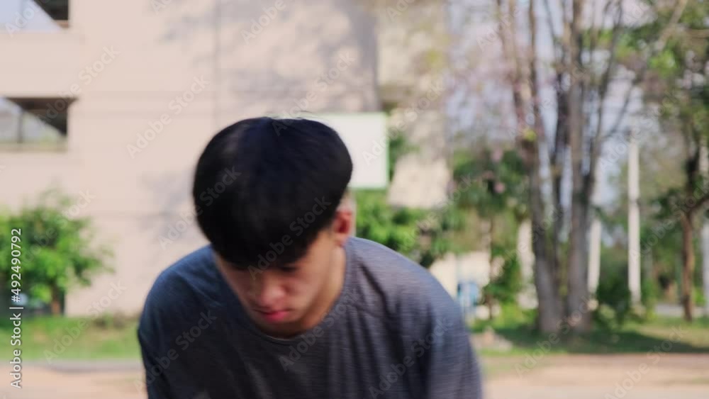 Young Asian athletic male playing basketball outdoors. Young sports men practicing basketball on the outdoor court. Young Asian athletic male playing basketball outdoors. Young sports men practicing basketball on the outdoor court.