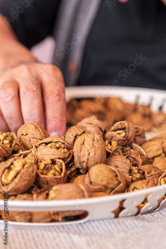 chopped walnut in a man's hand on white background