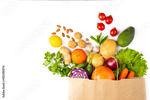 Healthy food background. Healthy vegetarian vegan food in paper bag vegetables and fruits on white, copy space, banner. Shopping food supermarket and clean vegan eating concept.