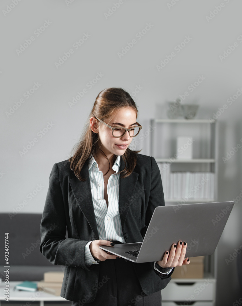 Business woman freelancer using laptop typing on pc notebook, surfing internet in office. Secretary woman in formal wear working on project at modern office. Business woman freelancer using laptop typing on pc notebook, surfing internet in office. Secretary woman in formal wear working on project at modern office.
