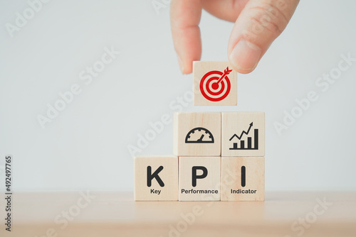  businessman holds cube with KPI (Key Performance Indicator) icon, business goals, performance results and indicators, for business planning and measure success, target achievement