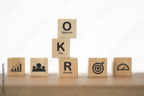 OKR black text (Objectives, Key and Results) on wooden cube blocks on table for business target and focus concepts