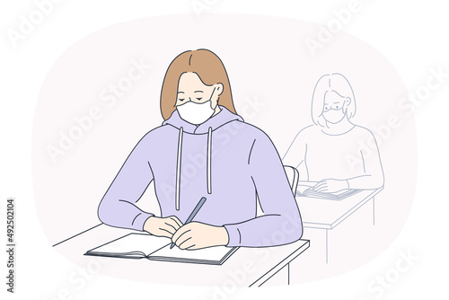 Students sit at desk in facemasks write in notebook study in school or university during covid-19. Girls in facial masks prepare task in college. Education in corona virus time. Vector illustration. 