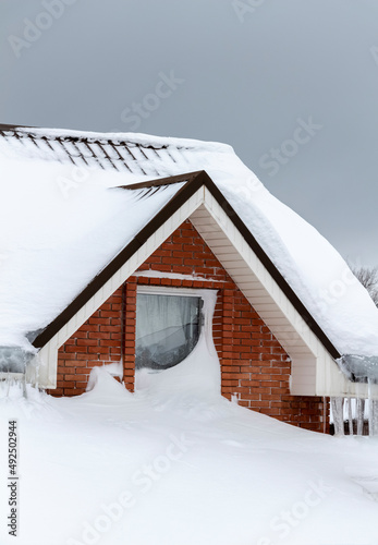The roof of a private house under a thick layer of snow.