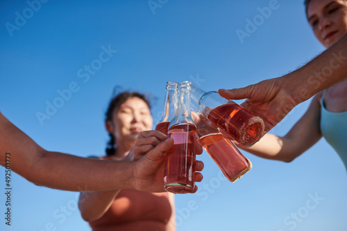 Close-up image of young people toasting with refreshing drinks at party