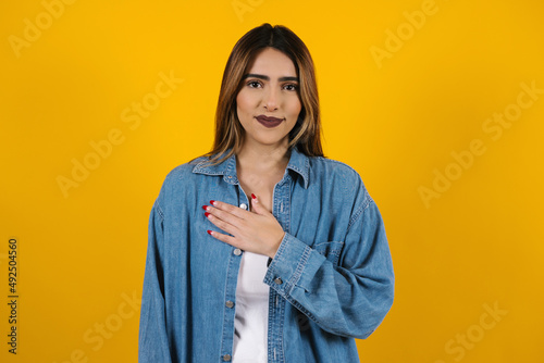 Young latin woman practicing breathing or meditating or yoga class on yellow background in Mexico Latin America  © Marcos