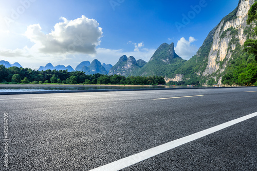 Asphalt highway and mountain natural scenery under blue sky in summer. Road and mountain background.