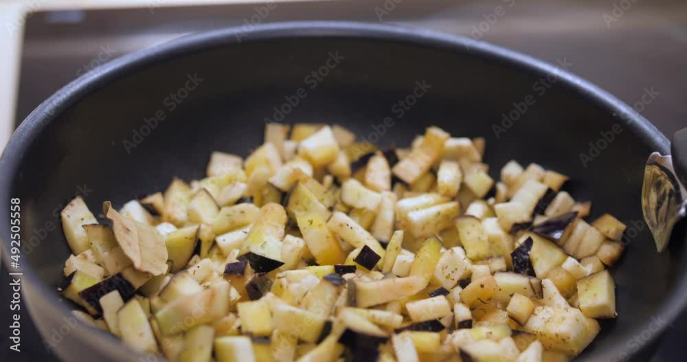 Fresh Eggplant Cut In Chunks Cooking In A Pan. close up, dolly-out Fresh Eggplant Cut In Chunks Cooking In A Pan. close up, dolly-out