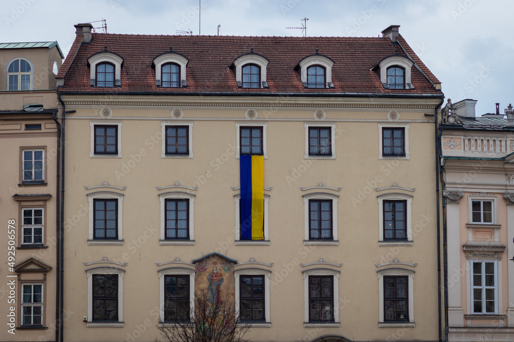 Fototapeta premium 09-03-2022. krakow-poland. Buildings in the main square of Krakow - Rynek Główny. Presenting the Ukrainian flag as identification with the Ukrainians in the Russo-Ukrainian War