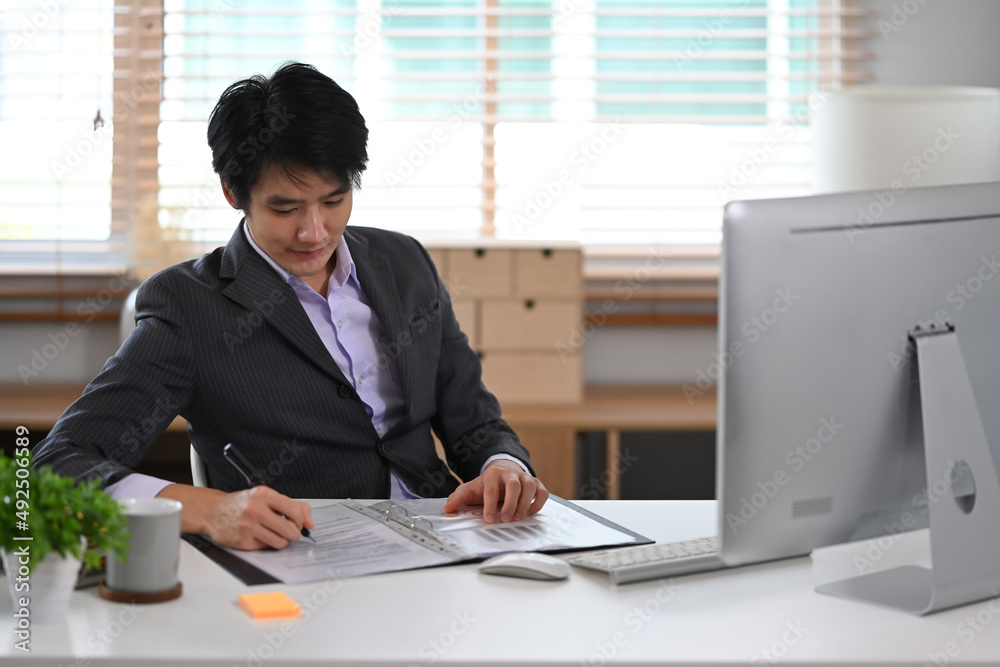 Concentrated financial advisor working with computer at bright modern office. Concentrated financial advisor working with computer at bright modern office.