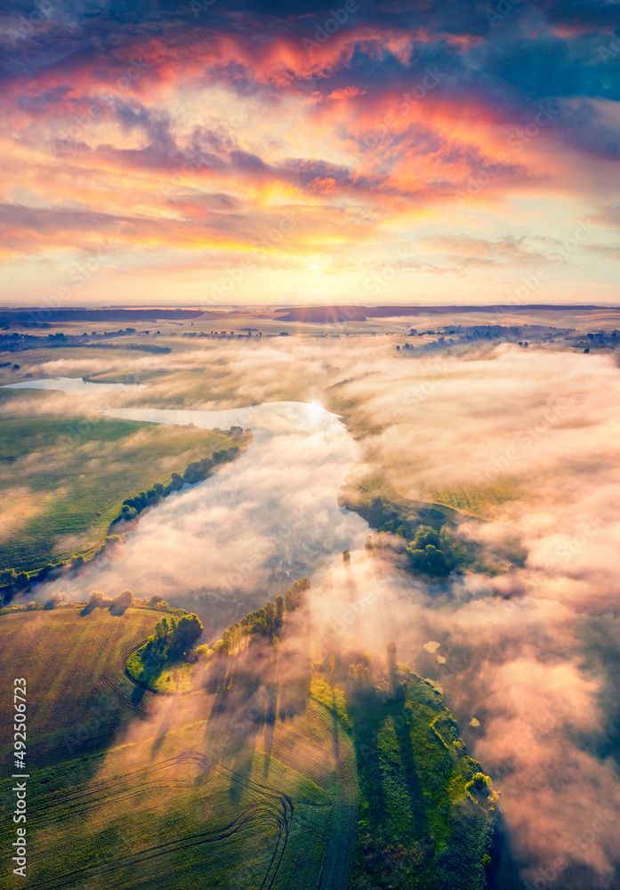 Fototapeta premium Astonishing summer scene of Ukrainian countryside, Ternopil region. Stunning morning view from flying drone of Angelivka lake. Foggy sunrise on Ukraine, Europe. Traveling concept background.