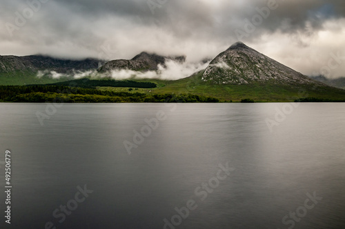 Low clouds surround the mountainous shoreline of the still and tranquil waters of Lough Inagh in Western Ireland. photo