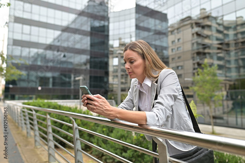 Businesswoman in town using smartphone photo