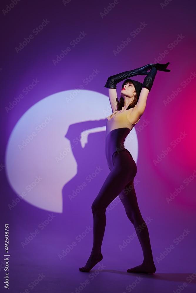Pretty young female posing on stage spotlight silhouette disco purple background unaltered