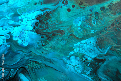 Fluid Art. Green and fluorescent blue abstract wave swirls on black background. Marble effect background or texture