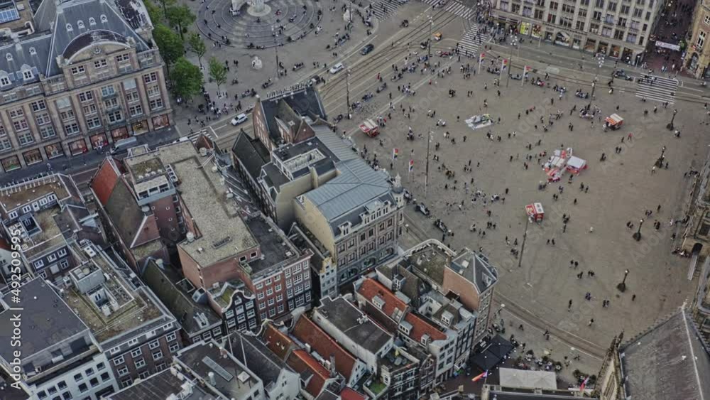 Amsterdam Netherlands Aerial v12 birds eye view drone fly around busy dam square capturing national monument and dutch architectures at binnenstad neighborhood with sun shining through - August 2021 Amsterdam Netherlands Aerial v12 birds eye view drone fly around busy dam square capturing national monument and dutch architectures at binnenstad neighborhood with sun shining through - August 2021