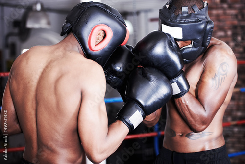 Upping each others game. Two boxers wearing protective gear sparring with one another. photo