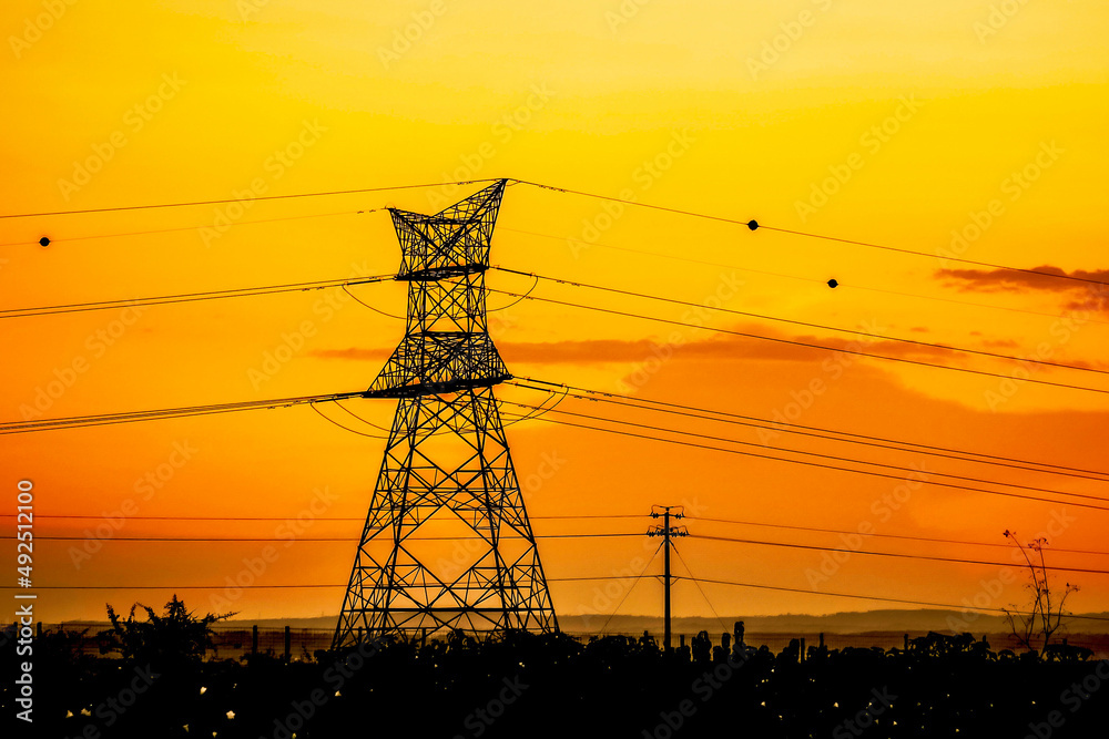 Power lines against a radiant sunset in rural Kenya