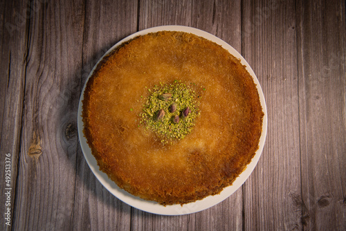 Photography Delicious Traditional Dessert Knafeh with cheese and pistachios and orange flowe