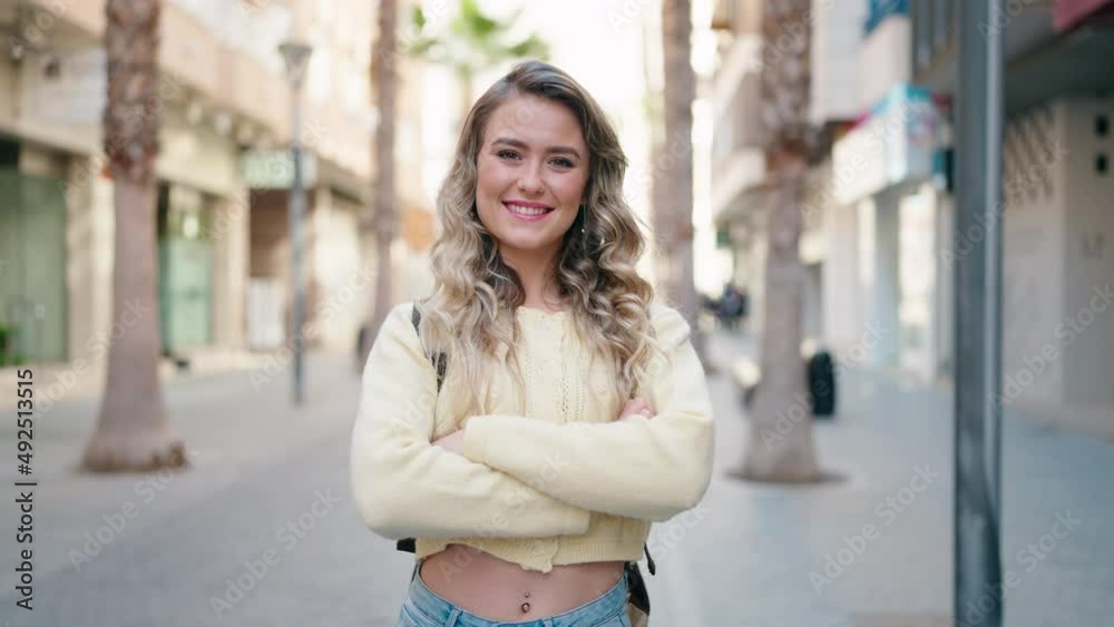 Young blonde woman tourist smiling confident standing with arms crossed gesture at street Young blonde woman tourist smiling confident standing with arms crossed gesture at street