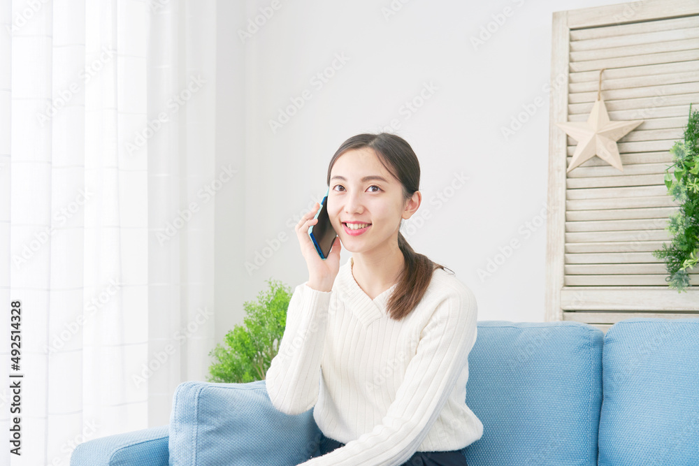 女性　スマホ　電話する　リビング