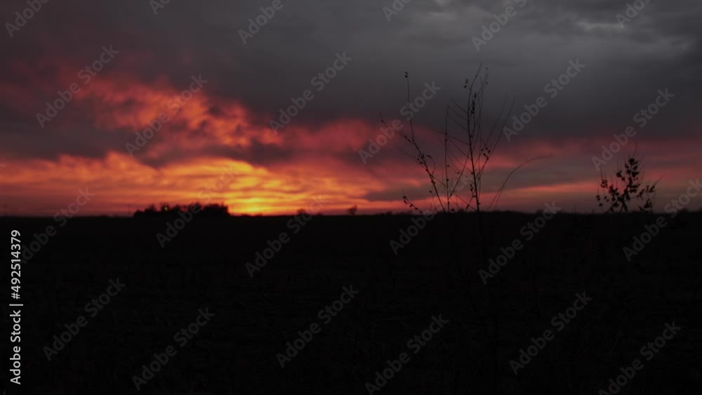 A beautiful red, orange and yellow sunset across a field with various colored clouds on a cool evening in Kansas. A beautiful red, orange and yellow sunset across a field with various colored clouds on a cool evening in Kansas.