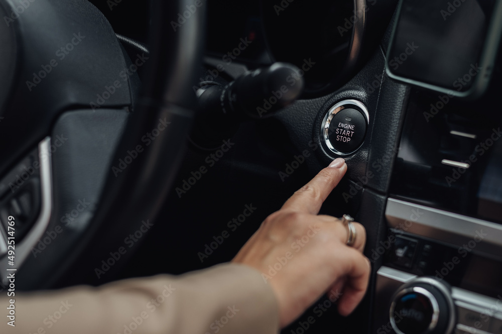 Woman Holding Finger on a Button to Start or Stop Engine of the Modern Car
