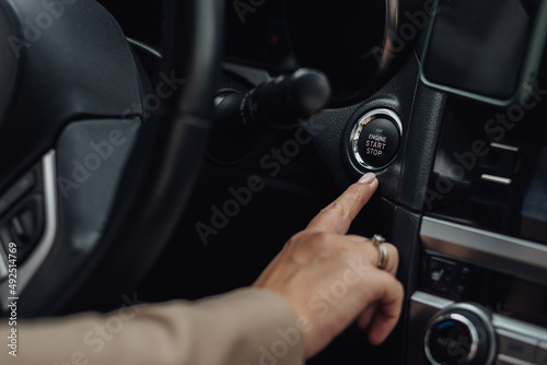 Woman Holding Finger on a Button to Start or Stop Engine of the Modern Car © Romvy