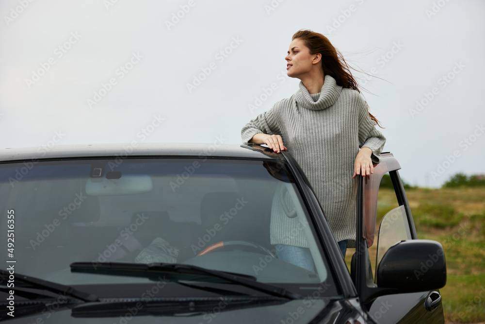 beautiful woman with red hair in a sweater near the car nature female relaxing beautiful woman with red hair in a sweater near the car nature female relaxing