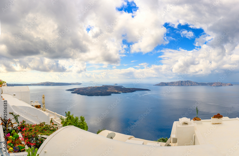 Fototapeta premium Picturesque view of the famous Greek resort of Thira, Santorini island. Traditional village with white houses with blue domes over Caldera, Aegean Sea. Greece. Summer holidays.
