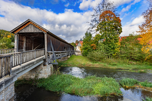 Roofed wooden bridge over the river Ilm in Buchfart, Thuringia, Germany.