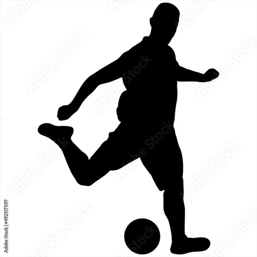 Black silhouette of a soccer player swinging his foot on the ball.