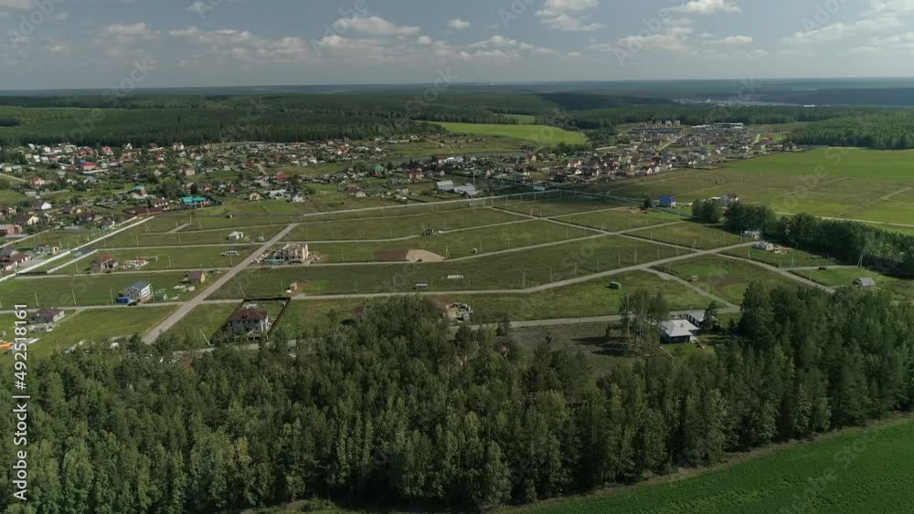 Aerial view of Empty residential area for the construction of private houses on the outskirts of the village. There are dirt roads and electricity on the territory. Around the meadows, fields and fore Aerial view of Empty residential area for the construction of private houses on the outskirts of the village. There are dirt roads and electricity on the territory. Around the meadows, fields and fore